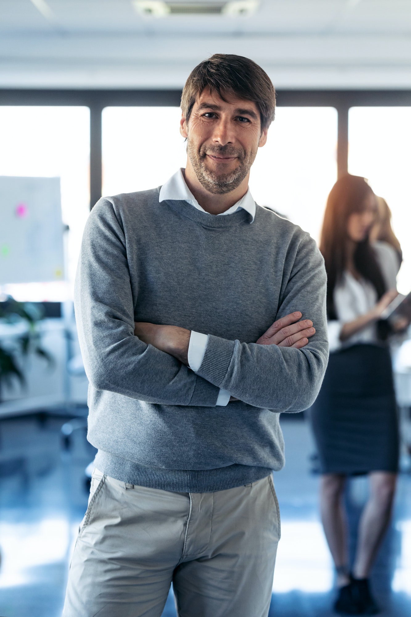 handsome businessman is looking at camera while his colleagues are working on coworking place .jpg